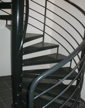 Escalier en acier laqué noir avec une main courante avec 5 sous-lisses et marches en tôles larmées. Maison des associations Luzinay